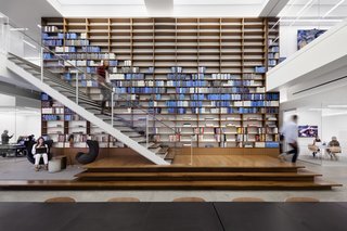 This wall of carefully arranged books at Warby Parker's NYC offices emphasizes their primary brand color in a unique way.