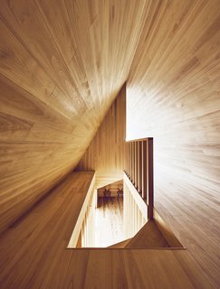 Looking down the stairway from above reveals another view of the "A" shape of the upper floor with contrasting angles created by light and shadow.