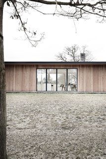 The home has been designed as a long, narrow, flat-roofed pavilion to fit naturally with existing structures. 