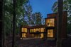Modern home with Exterior, House, Metal Roof Material, Metal Siding Material, and Flat RoofLine. Vast expanses of floor-to-ceiling glass and cantilevered windows overlook the forest behind the house. Photo 5 of Piedmont Retreat