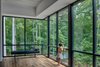 Modern home with Living Room, Bench, and Dark Hardwood Floor. Tonic's clients wanted to maintain a direct visual connection with their beautiful wooded site. The abundant glazing fulfills that wish. Photo 8 of Piedmont Retreat