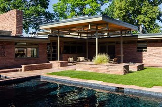 The swimming pool did not originate with the house, but<br>came about later in a 1980 design by Hans Kahn Associates,<br>Inc. The metalwork supporting the patio cover borrows<br>rhythm and form from nearby transom windows. In the<br>Hornbein-era backyard, grass and a swing set prevail, both<br>in the shadow of the second-story solarium.
