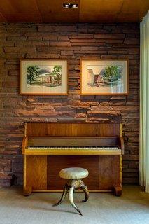 One of many custom extravagances is<br>an upright piano that Victor Hornbein<br>convinced Steinway & Sons to manufacture<br>using veneers specified for the<br>house. Hanging above are watercolors<br>that Hornbein himself painted, elegantly<br>rendering his architectural vision. An<br>accomplished artist as well as architect,<br>Hornbein executed large murals around<br>Denver under the tutelage of legendary<br>muralist Allen Tupper True.