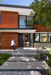 A concrete and crushed rock pathway leads to the house where the first view is of the three-level staircase. The sunken living room is to the left, offering wide street views.