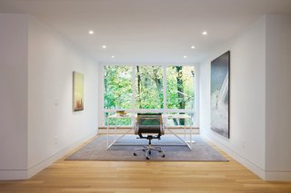 Situated on a sloped-site, each renovated space provides a unique perspective and vista to the dramatic natural surroundings. The office, with its stark modern furnishings and subtle artwork, allows the large window to serve as perhaps the most dramatic, singular frame to the foliage beyond. 