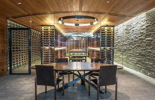 SLOPESIDE CELLAR – A technical challenge from the get-go, this below-grade wine cellar is an addition to a 10,000-square-foot ski-in-ski-out residence. Just breaking ground meant a dig that extended well below the lowest footings of the existing home. The cellar’s design features only four materials (glass, mahogany, blackened steel, and Valser Quartzite cut three different ways), and is intended to make a clean departure from the stone-and-timber aesthetic of the home. The climate-controlled cellar, which has a capacity of 7,500 bottles, is seen behind glass panels that are recessed into both the floor and the undulated ceiling. An exterior glass wall provides views of a series of cascades that collect in a terminal pool at eye level. Photos by Audrey Hall.