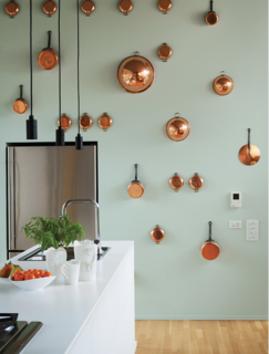 10 Effective Tips For Making the Most Out of Small Space Interiors - Photo 10 of 10 - A wall of artfully arranged copper pots with a contrasting paint color makes a bold statement in this small kitchen. 