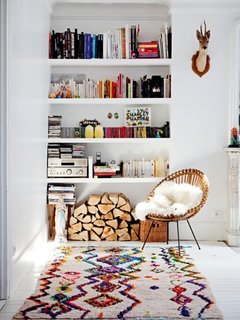 A recessed white bookshelf holds far more than just books.