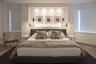 A wall at an angle in this apartment is masked by a centrally-focused bed and minimal, consistent window treatments.