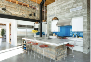 As the saying goes, the kitchen is always where guests gather—but this kitchen also happens to connect the living room and entry to a large outdoor patio with views of the lake. Philips dome pendants hang above a sizable marble island encircled by Bertoia counter stools by Knoll.