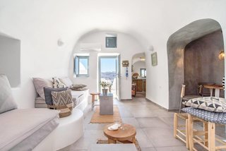 Ever Wanted to Stay in a Cave That’s Actually Pretty Modern Inside? - Photo 7 of 10 - Carved into the majestic Caldera cliffs of Santorini's most famous village, Oia, this yposkafo was renovated in 2016 and comes with an indoor and outdoor jacuzzi and an inviting interior finished with soft grays and pale blues.