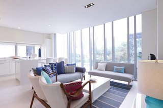 Decked out in plenty of white and cool grays and blues, this two-bedroom apartment sits in a luxury condominium in the heart of Singapore’s city center. Its floor-to-ceiling windows in the living room offer immersive views of the city. 