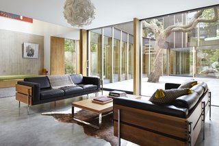 Built around a 100-year-old pear tree, the modern courtyard home of architect Jake Edgley takes full advantage of its surroundings, from the vertical wood boards to the way it fillsCourtesy of Jack Hobhouse the home with natural light throughout the day. 