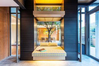 Inspired by the communal terrace courtyards of traditional multi-generational Thai homes, Thai architectural practice TA-CHA Design positioned a courtyard with a large tree in the center of the house to encourage circulation and increase interaction between household members. 