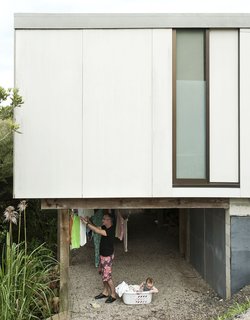 The homeowners of this New Zealand home have found a practical and passively sustainable alternative to a dryer as they hang their clothes out to dry in the ventilated space beneath the first floor of their house. 