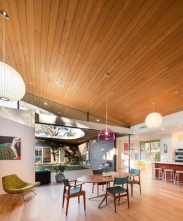 A large glassless opening on the sloping curved shed roof of this Californian home opens the courtyard to the sky and the elements, while giving the surrounding living areas an almost outdoor, park-like feel. 