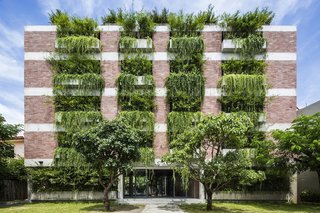 Designed by sustainable Vietnamese practice Vo Trong Nghia, the Atlas Hotel in Hội An, Vietnam, has more that 100 cantilevered concrete planters. The trailing plants that overhang from the balconies create the effect of a green facade that shades the guest rooms from the strong sunshine. 