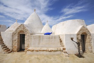 Discover 8 of the Best Mediterranean Homes - Photo 4 of 11 - Unique to Italy’s Apulia region, a trullo is an ancient hut with a conical roof that dates back to the medieval times. In the commune of Ostuni, you can stay at Brindisi Trulli, a traditional trullo structure that's been restored.