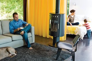 In this 880-square-foot home in the Wisconsin forest, custom curtains by Manhattan Textiles delineate the kitchen and sleeping room from the main space.