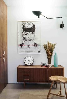 Mixing midcentury modern with pops of color, Eliza’s apartment has a full-height storage system that's built into one of the living room walls.