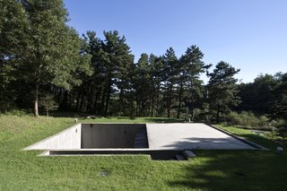 8 Subterranean Homes That Are Out of This World - Photo 2 of 8 - Buried in the middle of a forest clearing in Seoul, South Korea, Sugokri Earth House by BCHO Architects has two underground courtyards that are constructed out of concrete, as well as rammed-earth walls made from the excavated soil.