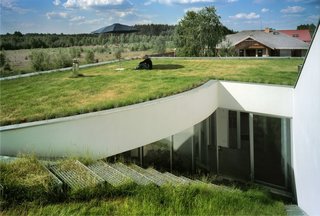 8 Subterranean Homes That Are Out of This World - Photo 7 of 8 - OUTrail House by Polish architectural practice KWK PROMES has a basement level that was "carved out" of a piece of the grass-covered site. The roof has been turned into a green atrium that blends in with its grassy surroundings.