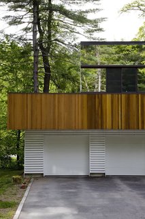Using mirrored siding and plate-glass windows, Boston architect Stephen Chung created an optical illusion where the second-story of a house surrounded by nature disappears seamlessly between the foliage and gabled roofs nearby.
