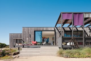 Sitting on the edge of a lake in the Mornington Peninsula, this house by Melbourne-based MA Architects was designed as a series of teak-clad modules with the main living areas in the center and a large deck that extends from the living room.