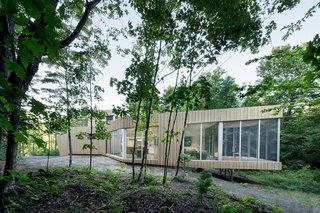 7 Incredible Modern Homes by Canadian Architect Paul Bernier - Photo 2 of 7 - The facade will turn gray and silver naturally, so its verticality, texture, and colors will blend in with the vertical tree trunks of the forest.