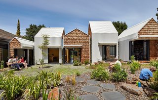 This Melbourne home designed by Andrew Maynard and Mark Austin is made up of a series of renovated gabled structures, and the contrast of its white steel panel and western red cedar shingle cladding emphasizes its geometric forms.