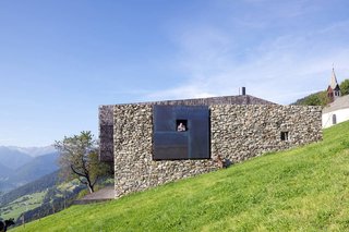 On the site of old farmhouse ruins in Italy, architecture firm Bergmeister Wolf Architekten built a new section with concrete, weathered steel, and wood shingles to contrast with the old stones.