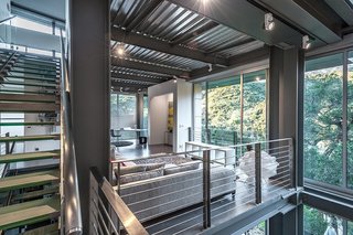 By combining a prefabricated, recycled-steel superstructure with concrete walls and insulated metal panels, architects Pamela and Hector Magnus built this charcoal-hued house with expansive second-floor windows.