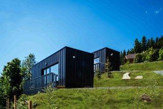 Four prefabricated alpine micro-houses by COMMOD-Haus were added to art-lodge—a boutique hotel in Carinthia, Austria. The transportable and environmentally friendly timber frame structures were delivered to their designated spot at the end of a winding mountain road and mounted securely with ground screws. The houses were assembled within hours and the only part that was built on ute was the terrace. Part of the farmhouse hotel complex, guests in the 248-square-foot micro-houses can use all of the hotel’s facilities.