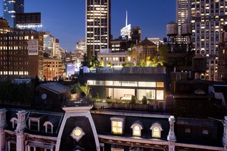 Located on the roof of the historic Gilsey House in Manhattan’s NoMad district, this renovated penthouse by STUDIO V Architecture has an expansive sliding glass door that retracts into the zinc facade, opening up the master suite to a garden terrace with restored historic handrails.