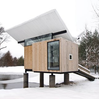 In Champaign, Illinois, this cedar hut by architect Jeffrey Poss was built as a raised platform that's accessed via a ramp. Inside are grass tatami mats, a miniature tea cabinet in a tokonoma alcove, and an oversized window that frames views of the trees. 