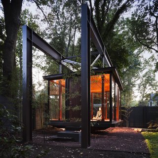 Suspended in a private residence's garden in the northwestern section of Washington, DC, this bronze-and-glass structure designed by David Jameson Architect Inc—which is illuminated from the ground up—looks like a Japanese tea pavilion, but is in fact a musical recital space that's also used as a room for dining and contemplation. 