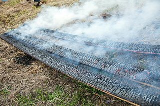 Shou sugi ban boards are left to cool on the ground.