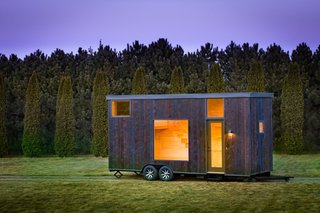 Named ESCAPE One, this tiny 276-square-foot Park Model RV trailer has an exterior of shou sugi ban siding and light-colored pine wood interiors.