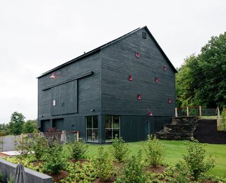 Inspired by a barn, which is part of the same property, this house in Hudson Valley, New York, was constructed from structural insulated panels from Vermont Timber Frames and clad in charred cedar. 