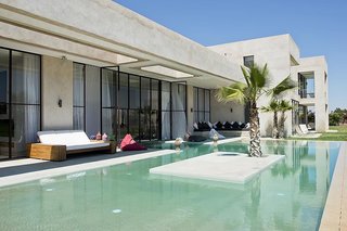 Discover 8 of the Best Mediterranean Homes - Photo 11 of 11 - Just 25 minutes from the medina of Marrakech, this contemporary Moroccan villa designed by Algerian architect Imaad Rahmouni celebrates Mediterranean living with lush gardens, an indoor/outdoor pool, retractable floor-to-ceiling windows, and a large semi-covered terrace that offers views of the Atlas Mountains.