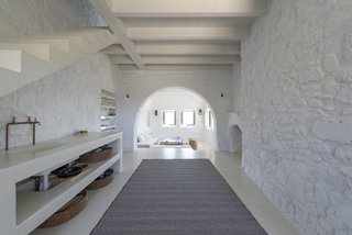 Within this minimalist villa on the Greek island of Nisyros are vaulted ceilings, arched doorways, wood beams, white-washed walls, and clean, contemporary furnishings in white, taupe, cream, and coffee tones.