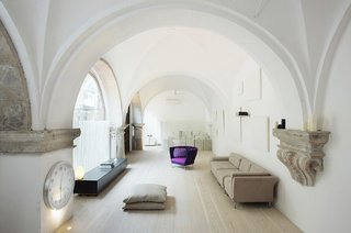 Vaulted cloisters in Barcelona that date back to the 1600s were converted into a vaulted residence by Estudio VilaBlanch. The incredible space features hand-carved stone details and columns, along with arched stained-glass windows.