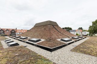 In the Belgian city of Knokke-Heist is a school designed by Amsterdam studio NL Architects, which has a turfed pyramidal roof with curving sides atop one of the administrative offices. 