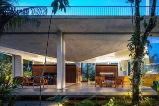 For this residence ensconced in nature near Brazil’s Itamambuca Beach, São Paulo studio Arquitetura Gui Mattos used a concrete slab for the roof structure, which takes the form of an inverted prism, with its tip pointing downwards from the center of the ceiling.