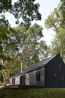 Perched atop a mountain on over six acres of woods, this young couple's weekend getaway incorporates the old with the new.