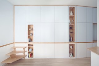 At one corner of the cabinet wall, a short flight of steps, shaped like a boat ladder, leads to another closet-like door that opens to a small portico.