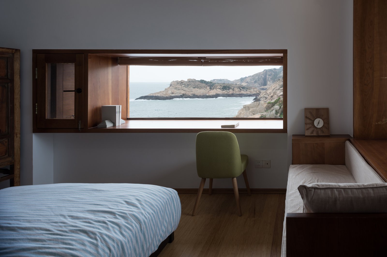 A window nook is used as a study desk in the bedroom.