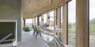 A study desk built into the glass walls on the ground floor provides a workspace with views.