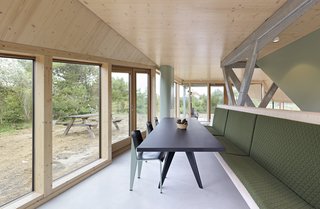 A dining table and bench accommodate the large family that occupies the summer home.