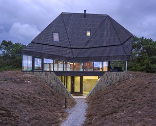 A concrete basement, where the bedrooms are located, is sunk beneath two dunes.